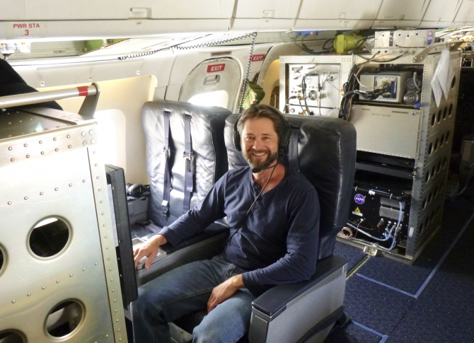 Karl Froyd, a former CIRES scientist during the Atmospheric Tomography Mission, is strapped in his workstation aboard the NASA DC-8 during one of the flights. Measurements made by the PALMS instrument allowed the research team to document that desert dust is a major contributor to the formation of icy cirrus clouds. Credit: Dan Murphy, NOAA